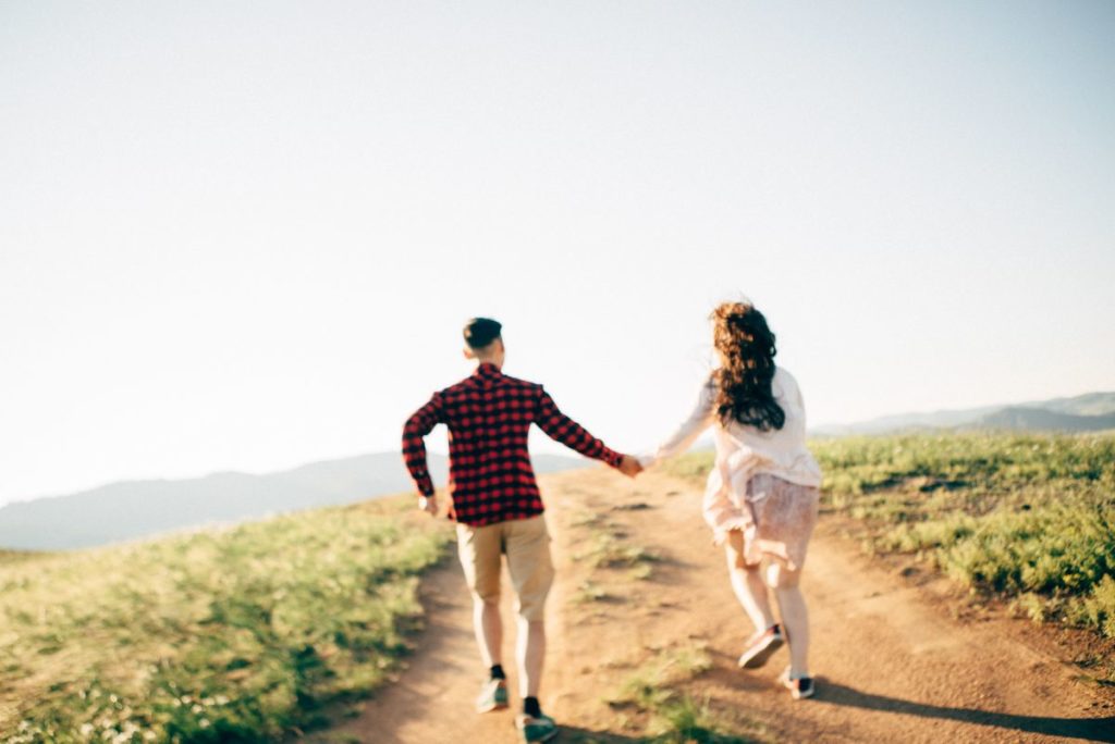 couple in a field facing the stages of a relationship together